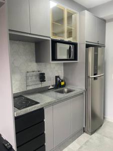 eine Küche mit einer Spüle und einem Kühlschrank in der Unterkunft Studio Acolhedor e Moderno no Centro de São Paulo! in São Paulo