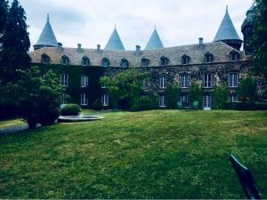 a large building with turrets on a grass field at Maison de 2 chambres avec jardin clos et wifi a Coltines in Coltines