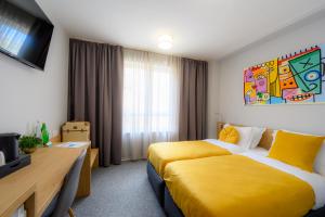 ein Hotelzimmer mit 2 Betten und einem TV in der Unterkunft LOCATION in Sofia