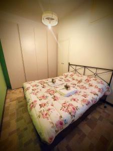 1 dormitorio con 1 cama con colcha de flores en WATERCOLOR House ,fibra internet and Disney plus, en Milán