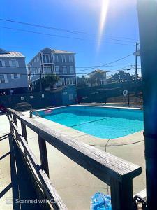 a swimming pool with a wooden bench next to it at Bikini Bottom in Carolina Beach
