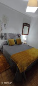 1 dormitorio con 1 cama grande con almohadas amarillas en Apartamento Fazunchar, en Figueiró dos Vinhos