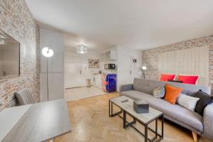 een woonkamer met een bank en een tafel bij Magnifique studio la villette avec parking in Aubervilliers