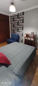 1 dormitorio con 1 cama grande y 1 sofá azul en Apartamento Fazunchar, en Figueiró dos Vinhos