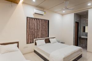 een slaapkamer met 2 bedden en een raam bij HOTEL AYODHYA in Virpur