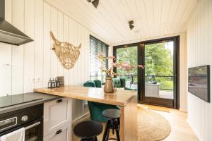 a kitchen with a table and some green chairs at Onder het dak van Brabant in Mierlo