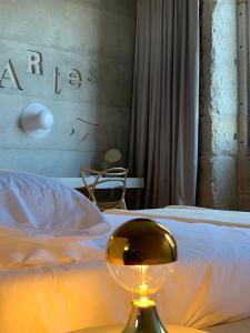 a bedroom with a white bed with a gold bowl on a table at Element in Viseu