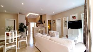 - un salon avec un canapé blanc et une télévision dans l'établissement Apartamento EL PATIO, à Fuengirola