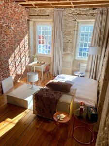 a bedroom with a bed and a table and windows at Element in Viseu