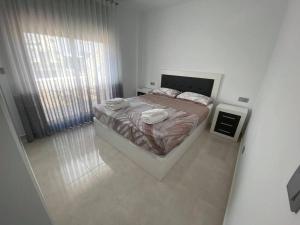 a white bedroom with a bed and a window at Villa Murcia Paradise in Los Alcázares +11 photos