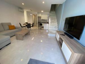 a living room with a couch and a flat screen tv at Villa Murcia Paradise in Los Alcázares