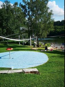 ein Volleyballnetz in einem Park neben einem See in der Unterkunft Tinyhouse am See im Donau-Ries in Wemding