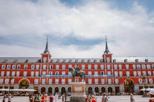 um grande edifício vermelho com uma estátua em frente em Lujo exclusividad espacioso Madrid centro em Madri