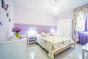 1 dormitorio con 1 cama y 1 mesa con flores en Almaré B&B, en Crotone