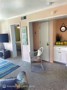uma sala de estar com uma cadeira e um quarto em Bikini Bottom em Carolina Beach
