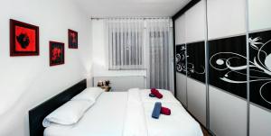 1 Schlafzimmer mit 2 Betten mit roten und blauen Kissen in der Unterkunft City Osijek, CENTAR, SELF CHECK IN in Osijek