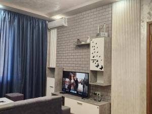 a living room with a tv and a blue curtain at Apartment at Abovyan Street in Yerevan