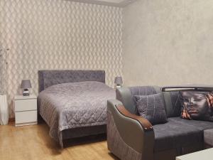 a bedroom with a bed and a couch at Apartment at Abovyan Street in Yerevan