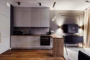 una cocina con armarios blancos y un aparato negro en APARTAMENTY ARTE LUBLIN Wikana Residence garaż, en Lublin