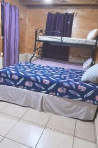 Cabaña Los Naranjos في Los Naranjos: غرفة نوم عليها سرير وبطانية زرقاء
