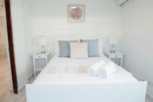 a bedroom with a white bed with two white tables at Family Cozy Apt 1 w/ 4 Beds & Sofa Bed @ Santurce - Barrio obrero apt 1 in San Juan