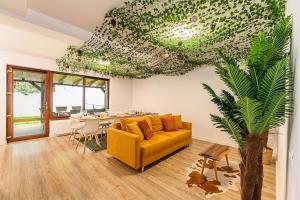 a living room with a yellow couch and a table at Safari Family Villa near Park Aventura,Lake,Zoo in Braşov