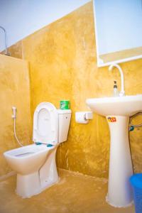 a bathroom with a toilet and a sink at Bara Accommodations Paje in Paje