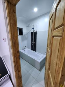 a bathroom with a bath tub and a sink at Swift Haven Studio Bamburi in Mombasa