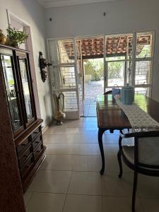 a dining room with a table and a door to a patio at Casa Grande Hospedagem in Brumadinho