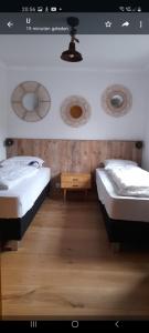2 łóżka pojedyncze w pokoju z drewnianą podłogą w obiekcie Tante Hanna w mieście Winterberg