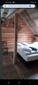 a bed in a room with a wooden wall at Tante Hanna in Winterberg