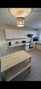 a kitchen with a wooden table and a light at Entire 3 bedrooom holiday home in Liverpool