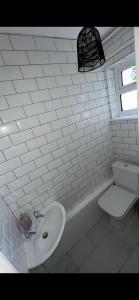 uma casa de banho branca com um lavatório e um WC em Entire 3 bedrooom holiday home em Liverpool