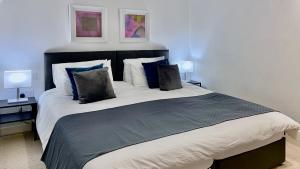 a bedroom with a large bed with two lamps at Maberic Housing II in Hounslow