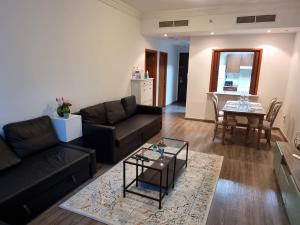 - un salon avec un canapé et une table dans l'établissement Granada Apartments MAG 218, à Dubaï