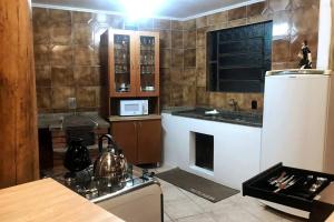 a kitchen with a stove and a refrigerator at Galpão Rústico no Vale dos Vinhedos in Bento Gonçalves