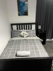 a bed with a black frame and a gray blanket at OAKhouse studio 76 in Kent