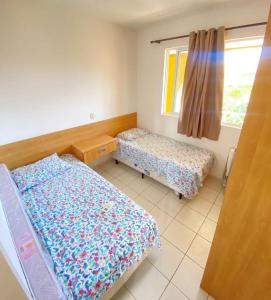 a bedroom with two beds and a window at Apto 2quartos Buzios/Vista p/mar/Piscina in Nísia Floresta