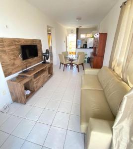 a living room with a couch and a flat screen tv at Apto 2quartos Buzios/Vista p/mar/Piscina in Nísia Floresta