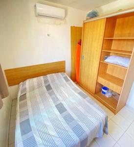 1 dormitorio con 1 cama y armario de madera en Apto 2quartos Buzios/Vista p/mar/Piscina en Nísia Floresta