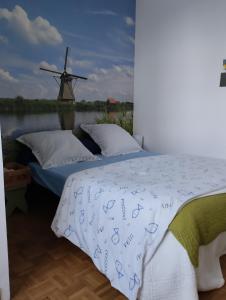 ein Schlafzimmer mit einem Bett mit einer Windmühle im Hintergrund in der Unterkunft chambres d'hôtes du clos du roi in Pontorson
