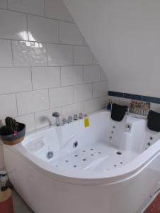 a large white bath tub in a room at chambres d'hôtes du clos du roi in Pontorson