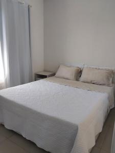 a bedroom with a bed with white sheets and pillows at Apartamento Campos dos Goytacazes de 3 quartos com ar condicionado in Campos dos Goytacazes +23 photos