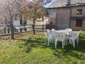 una mesa blanca y sillas en un patio en Gran Paradiso en Alpette