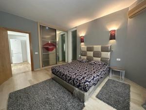 a bedroom with a bed and two rugs in it at Thé Wave au lac2 in Tunis