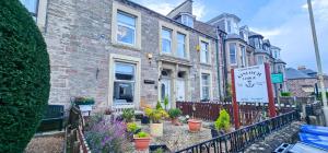 a building with a sign in front of it at mySTAYINN Kinloch 7 Bedroom House in Inverness