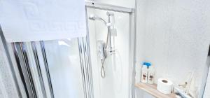 a shower with a glass door in a bathroom at mySTAYINN Kinloch 7 Bedroom House in Inverness +75 photos
