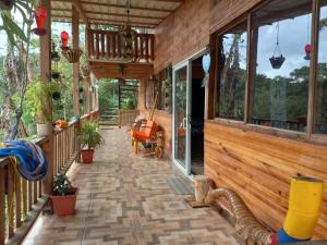 a screened in porch of a wooden house with windows at LA CASA DEL BOSQUE Via SALADITO in La Elvira