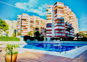 a swimming pool in front of some tall buildings at Viernes Home in Torrox Costa