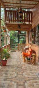un patio al aire libre con una terraza de madera con un columpio en LA CASA DEL BOSQUE Via SALADITO en La Elvira